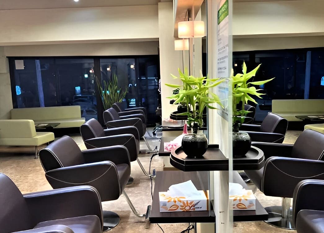 Modern interior of パリ美容室 in Shinjuku City, Tokyo, JP, showing sleek chairs and elegant decor.