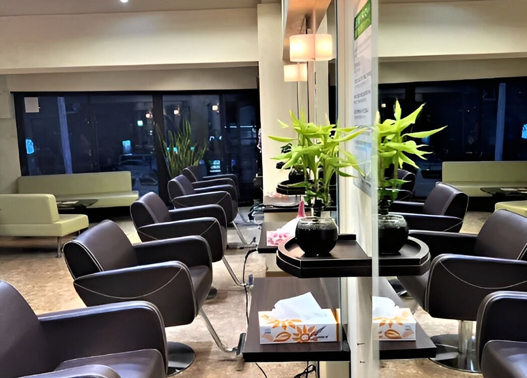 Modern interior of パリ美容室 in Shinjuku City, Tokyo, JP, showing sleek chairs and elegant decor.