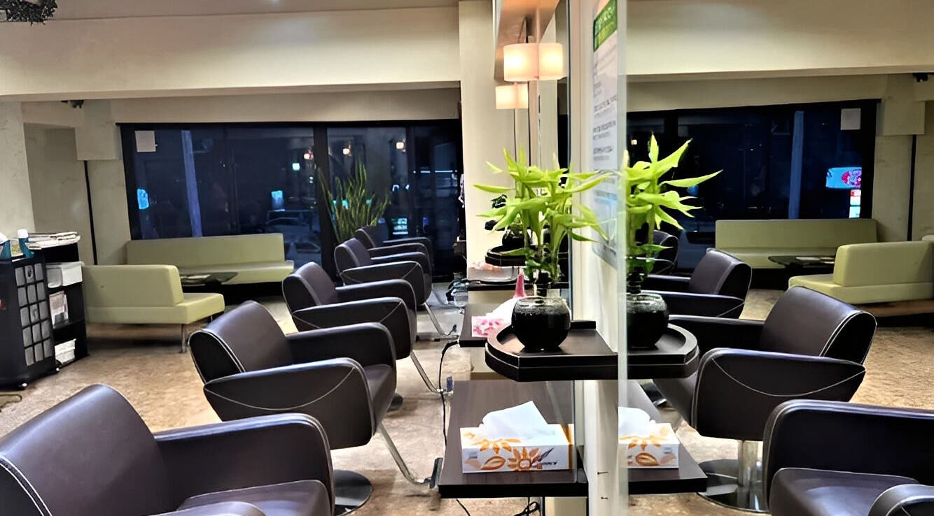 Modern interior of パリ美容室 in Shinjuku City, Tokyo, JP, showing sleek chairs and elegant decor.