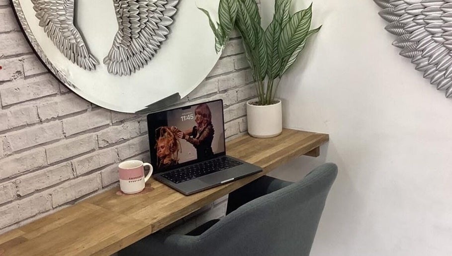 Stylish workspace at Hair by Janine at Shelley Lane Salon, Aberkenfig, Wales, GB featuring plant decor and laptop.