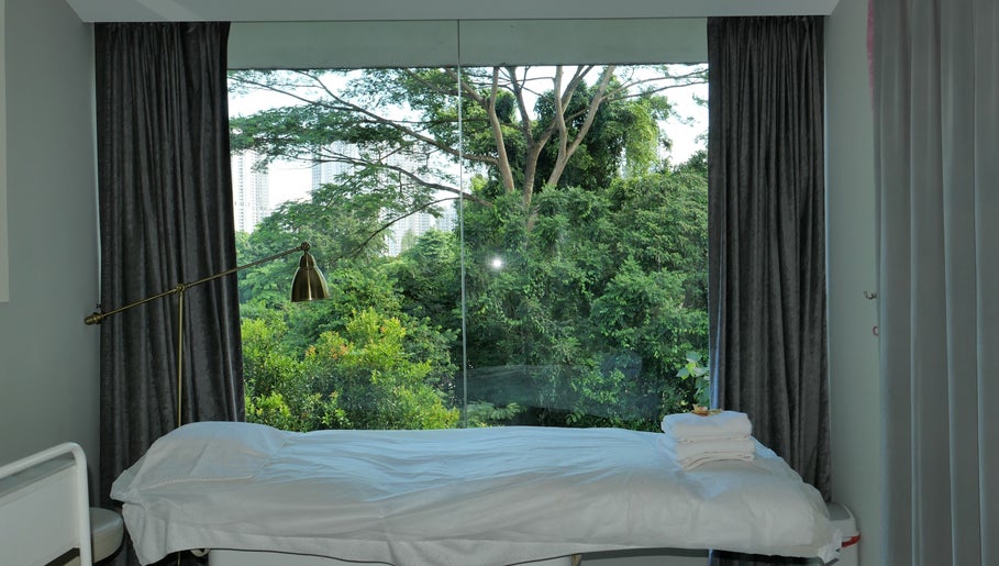 Peaceful treatment room at Reverie On Hill, Singapore, SG, with lush green views for relaxation.