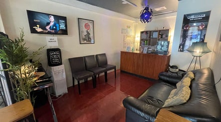 Cozy waiting area at Fade’N Cut Barber Shop in Paranaque City, Metro Manila, PH with couches and decor.