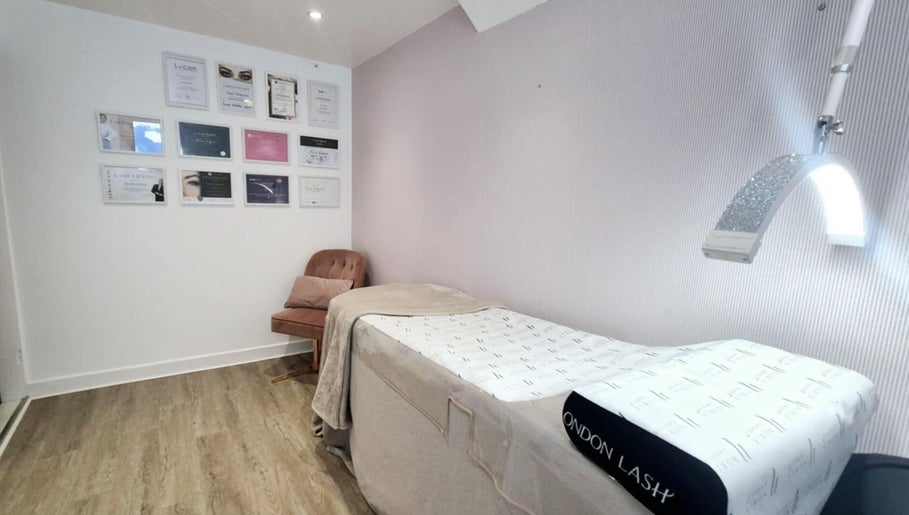 Kameralny pokój zabiegowy w Bella Estetica Cheltenham, Cheltenham, England, GB z łóżkiem i ozdobami ściennymi.