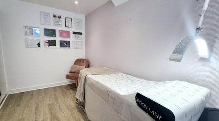 Kameralny pokój zabiegowy w Bella Estetica Cheltenham, Cheltenham, England, GB z łóżkiem i ozdobami ściennymi.