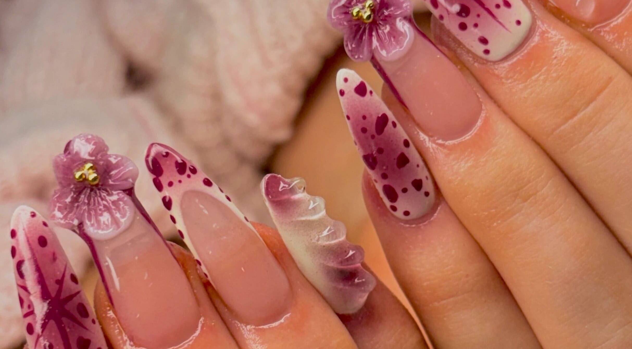 Ornate floral nail art at Nails By Florence in Douglas, IM, showcasing intricate purple blossoms.