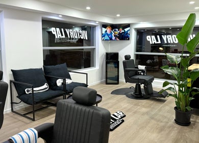 Modern interior of Victory Lap Barbershop in Melbourne, Victoria, AU featuring stylish chairs and decor.