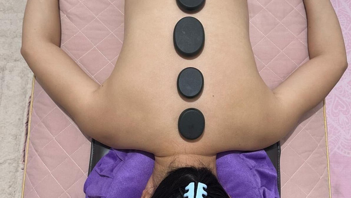 Hot stone therapy at J&J's Massage Therapy, Dalyellup, Western Australia, AU, featuring smooth stones on back.
