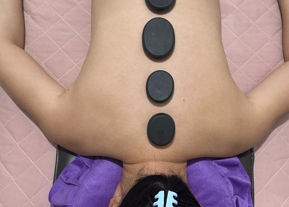 Hot stone therapy at J&J's Massage Therapy, Dalyellup, Western Australia, AU, featuring smooth stones on back.