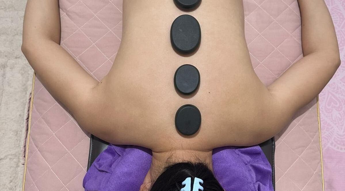 Hot stone therapy at J&J's Massage Therapy, Dalyellup, Western Australia, AU, featuring smooth stones on back.