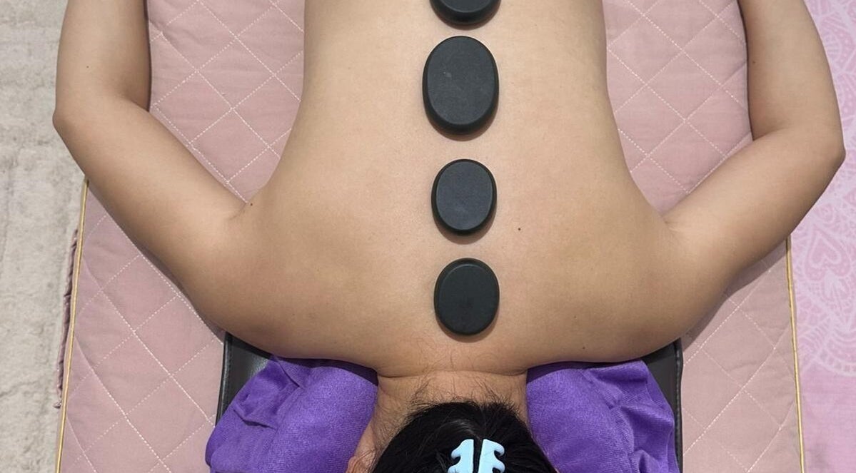 Hot stone therapy at J&J's Massage Therapy, Dalyellup, Western Australia, AU, featuring smooth stones on back.
