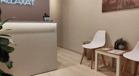 Recepción moderna en Relaxat, Barcelona, Catalunya, ES con sillas blancas minimalistas y decoración acogedora.