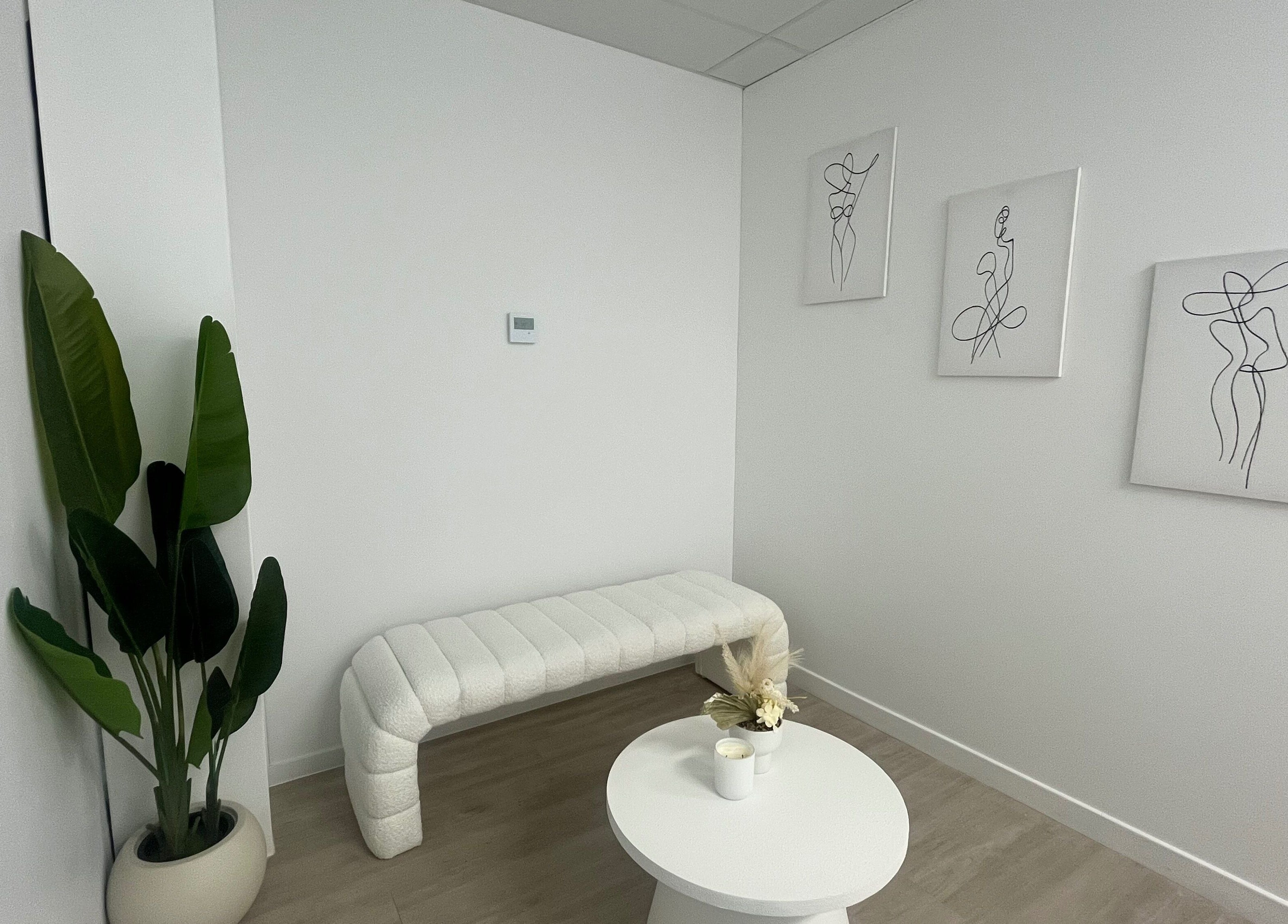 Minimalist waiting area at Ayami in Melbourne, Victoria, AU with a white bench and modern art.