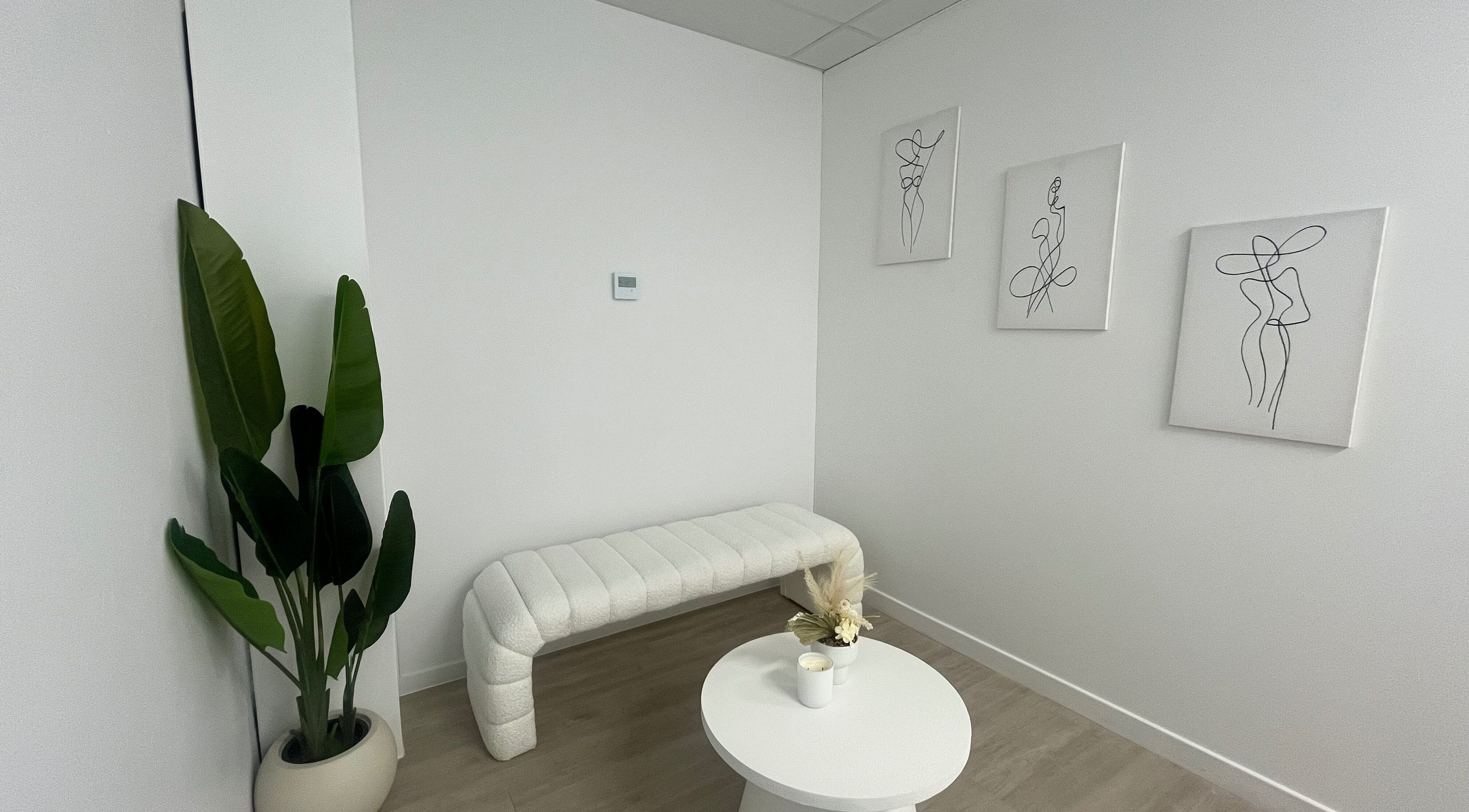 Minimalist waiting area at Ayami in Melbourne, Victoria, AU with a white bench and modern art.