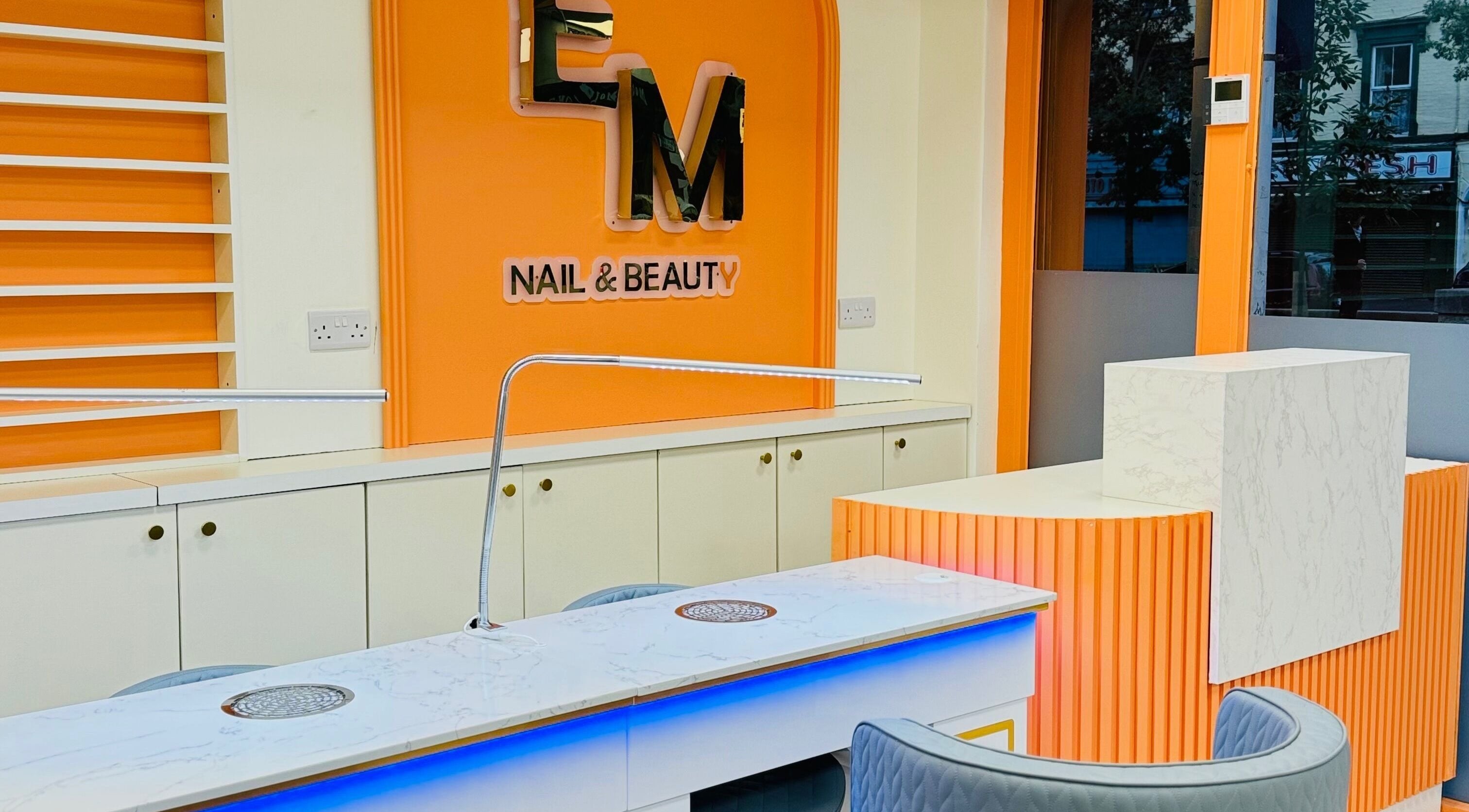 Elegant nail station at EM nail & beauty, Bray, County Wicklow, IE, featuring modern orange and white decor.