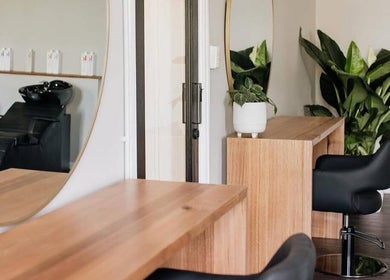 Modern salon interior at Hair by Neomai - SOUTH MELBOURNE, featuring chic wooden desks in Melbourne, Victoria, AU.