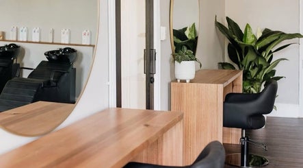 Modern salon interior at Hair by Neomai - SOUTH MELBOURNE, featuring chic wooden desks in Melbourne, Victoria, AU.