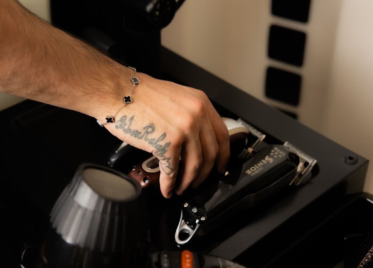 Close-up of a hand reaching for grooming tools at Fadetown, Riyadh, Riyadh Province, SA.