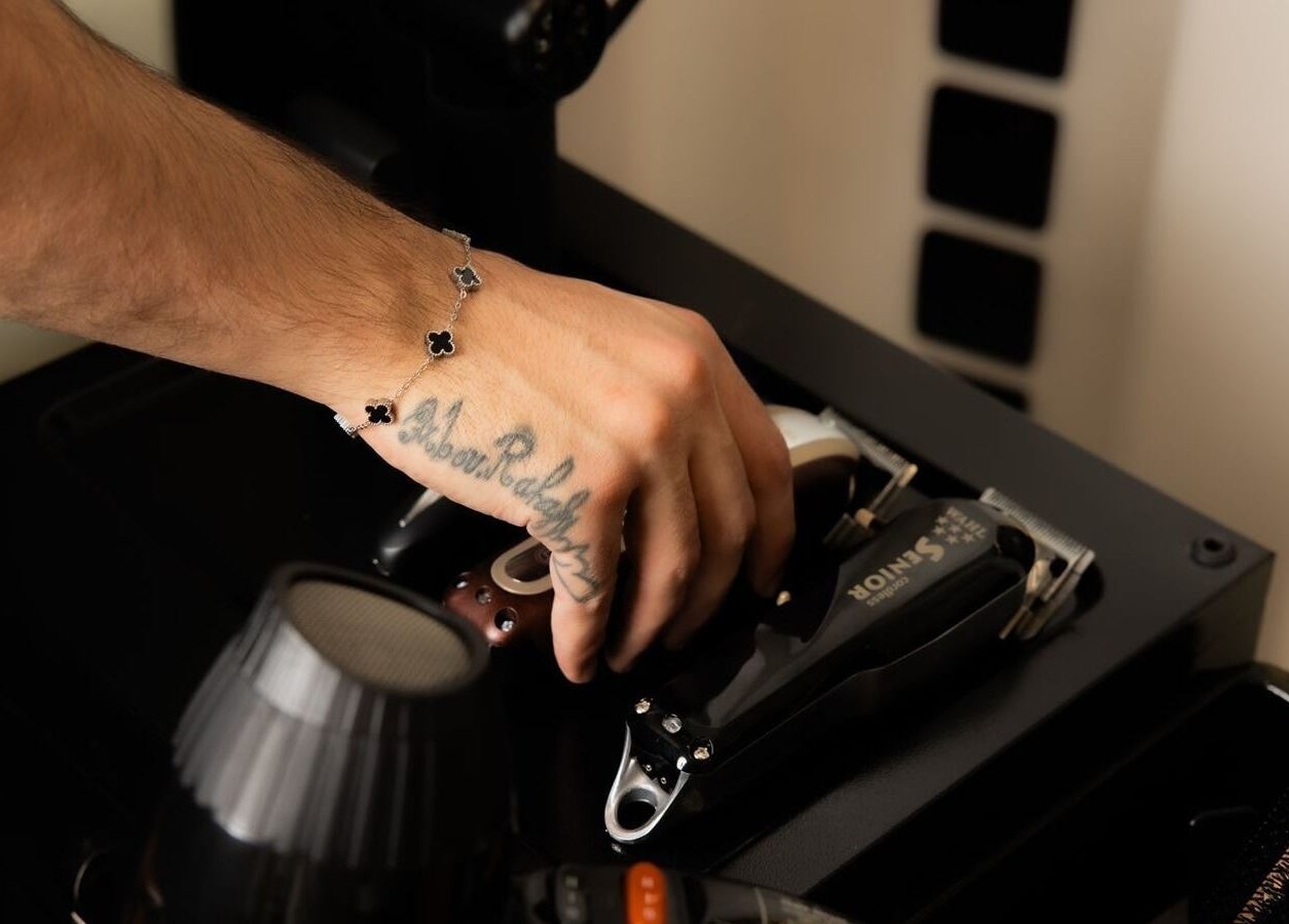 Close-up of a hand reaching for grooming tools at Fadetown, Riyadh, Riyadh Province, SA.