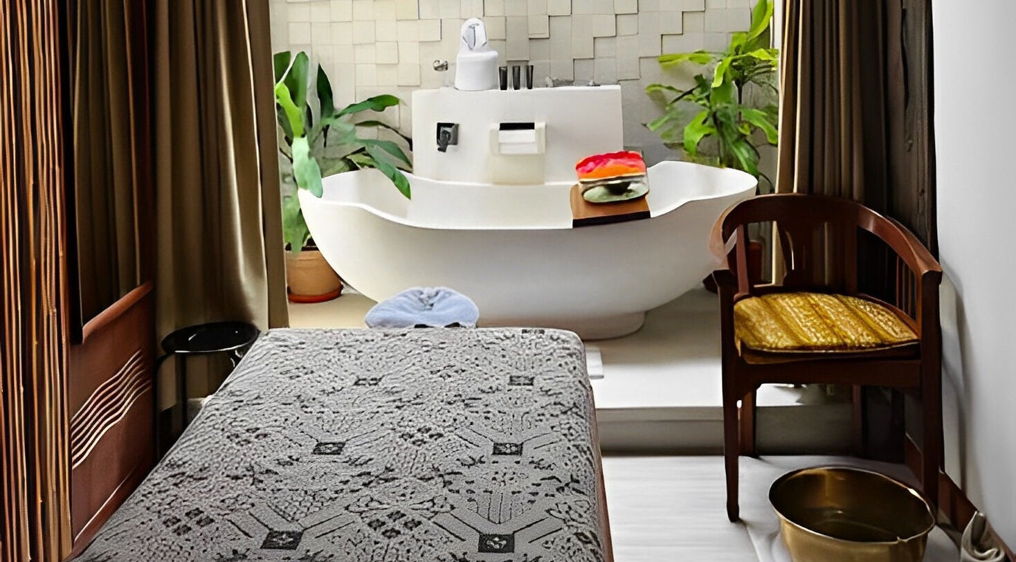 Area spa mewah di Anjali Spa, Badung, Bali, ID dengan bak mandi elegan dan dekorasi hijau menenangkan.