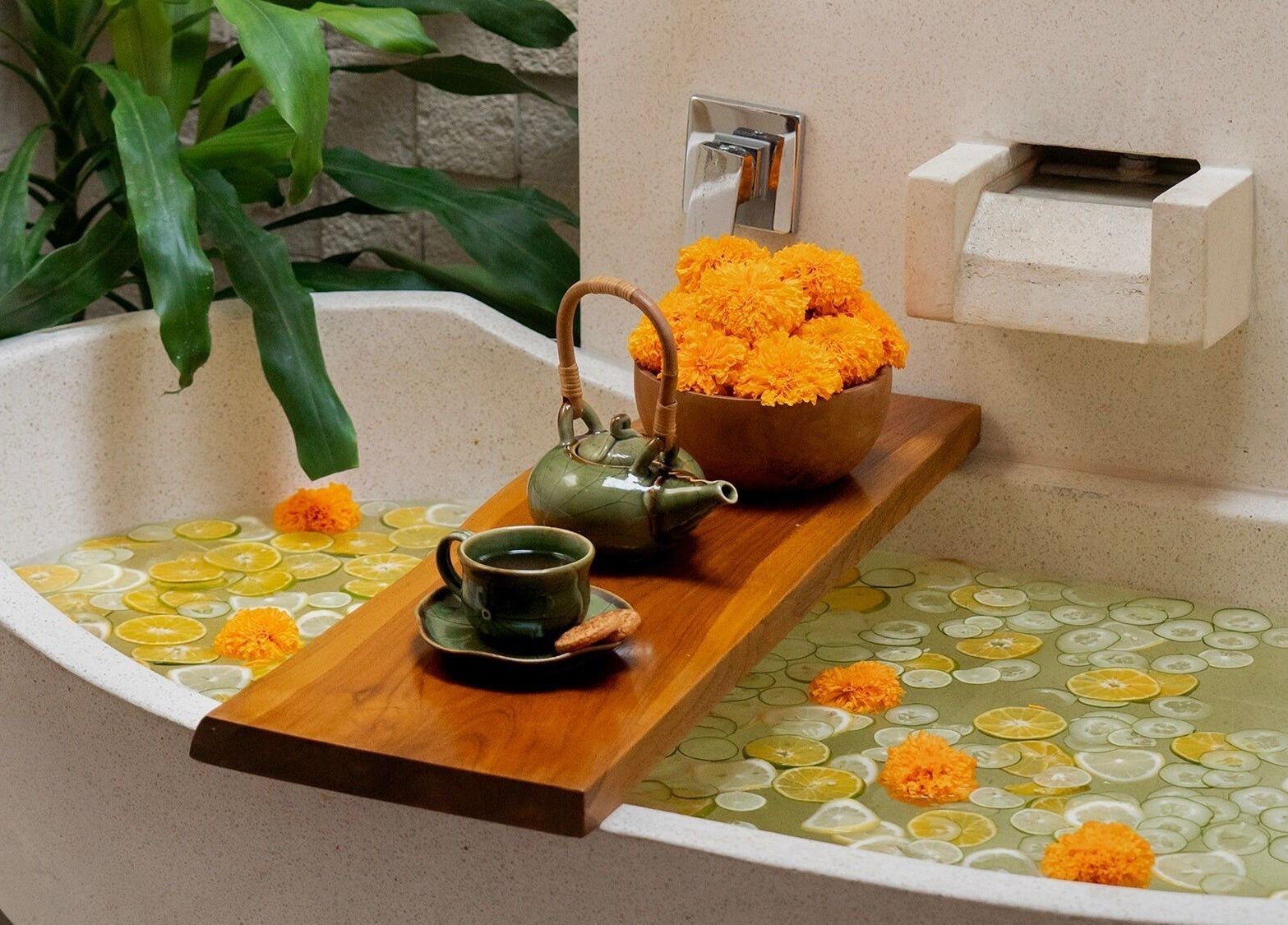 Suasana relaks di Anjali Spa, Badung, Bali, ID dengan bunga marigold dan teh di bathtub klasik.