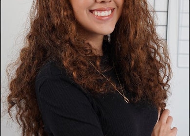 Smiling woman with curly hair at PaoLash Lounge, Dublin, County Dublin, IE. Experience premium beauty services.