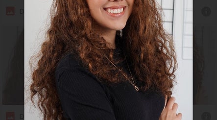 Smiling woman with curly hair at PaoLash Lounge, Dublin, County Dublin, IE. Experience premium beauty services.