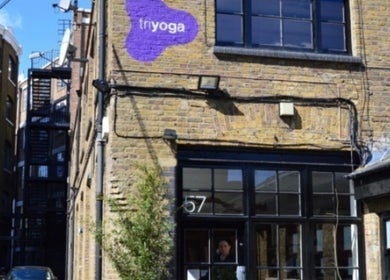 Charming brick exterior of By Adriane Roman in London, England, GB with purple signage.