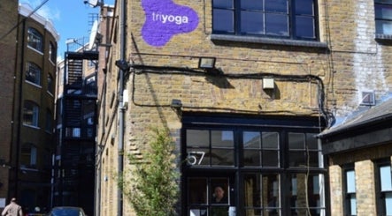 Charming brick exterior of By Adriane Roman in London, England, GB with purple signage.