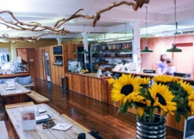 Cozy wooden lounge at By Adriane Roman in London, England, GB, with sunflowers and eclectic decor.