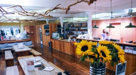 Cozy wooden lounge at By Adriane Roman in London, England, GB, with sunflowers and eclectic decor.