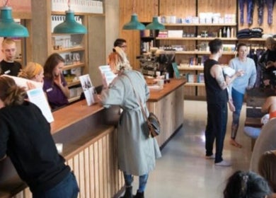 Vibrant reception area at By Adriane Roman in London, England, GB. Guests engage at the welcoming counter.