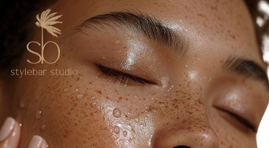 Close-up of a serene face with dewy skin at Stylebar Studio, West Bay, KY.