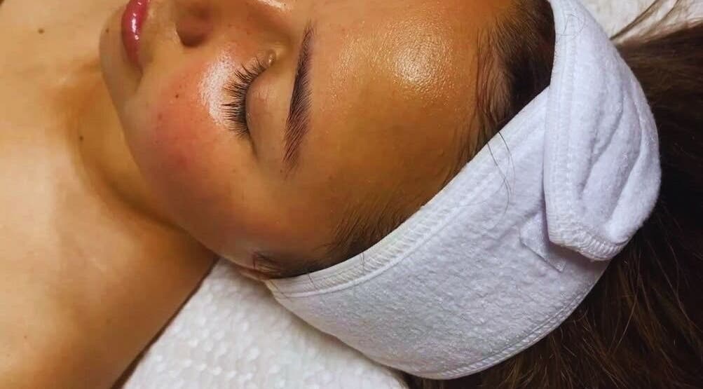 Relaxing facial treatment at Stylebar Studio, West Bay, KY. Person with closed eyes and headband enjoys pampering.