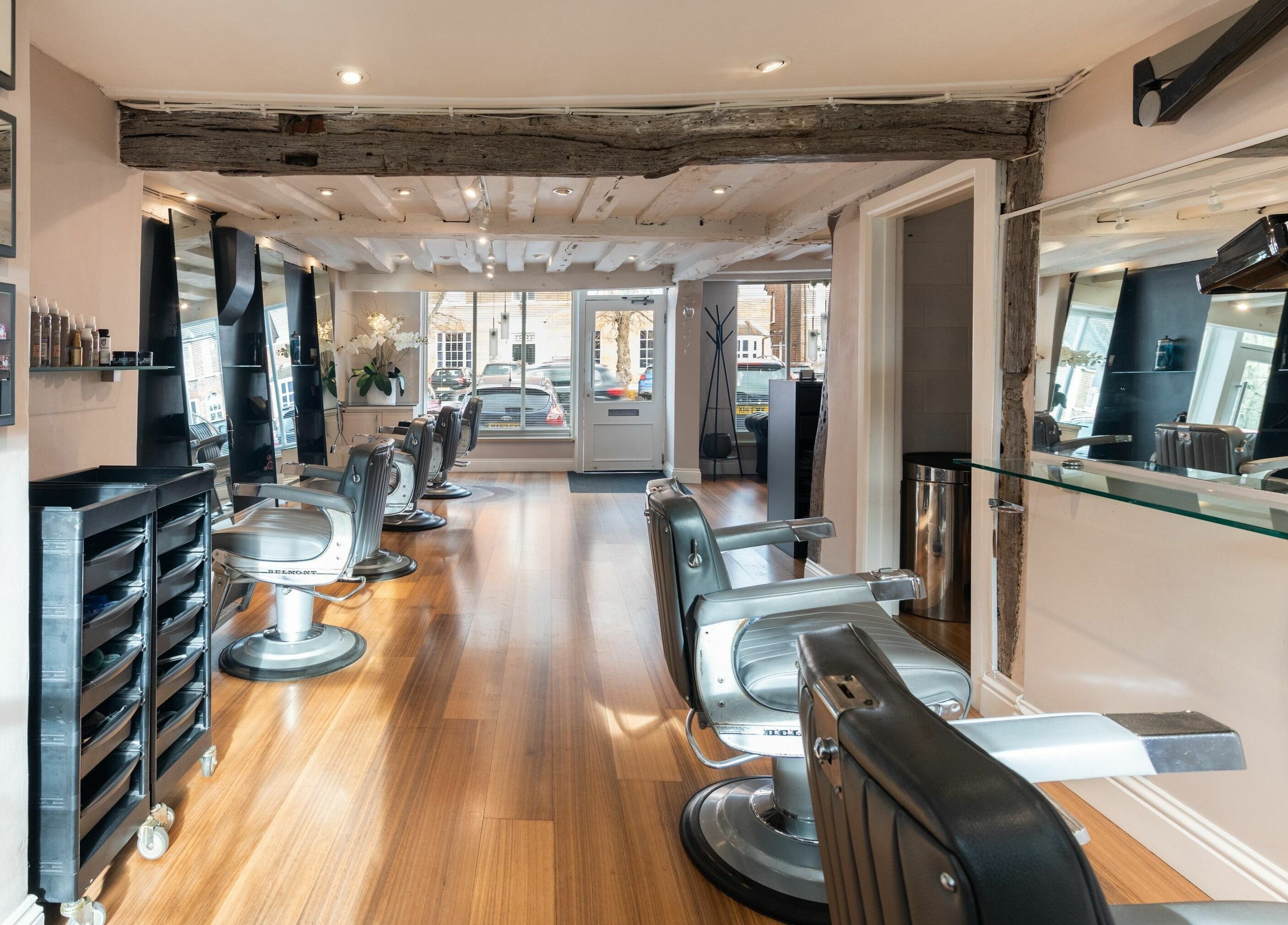 Modern interior of Albemarle Haircutters in Beaconsfield, England, GB, featuring stylish barber chairs and mirrors.