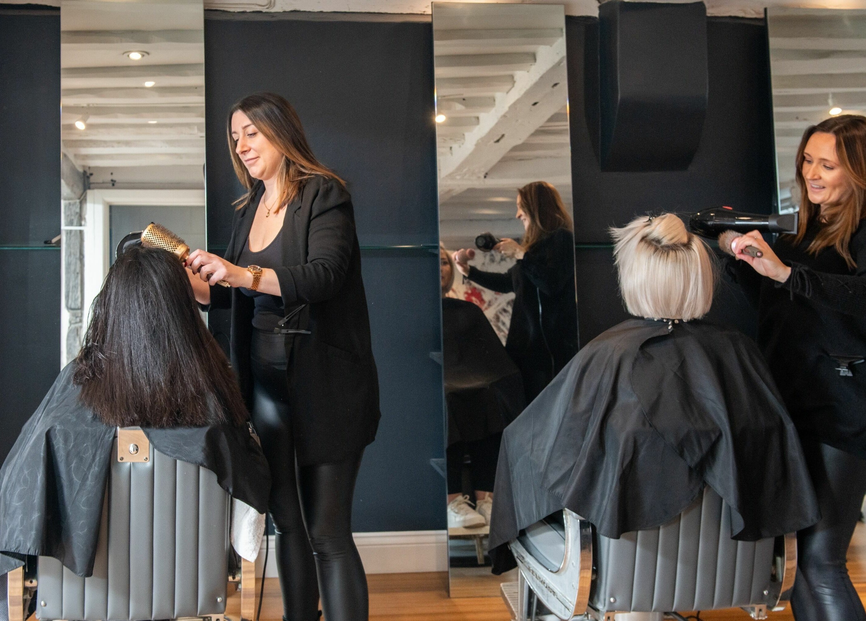 Professional hairstylists at Albemarle Haircutters in Beaconsfield, England, GB styling clients' hair.