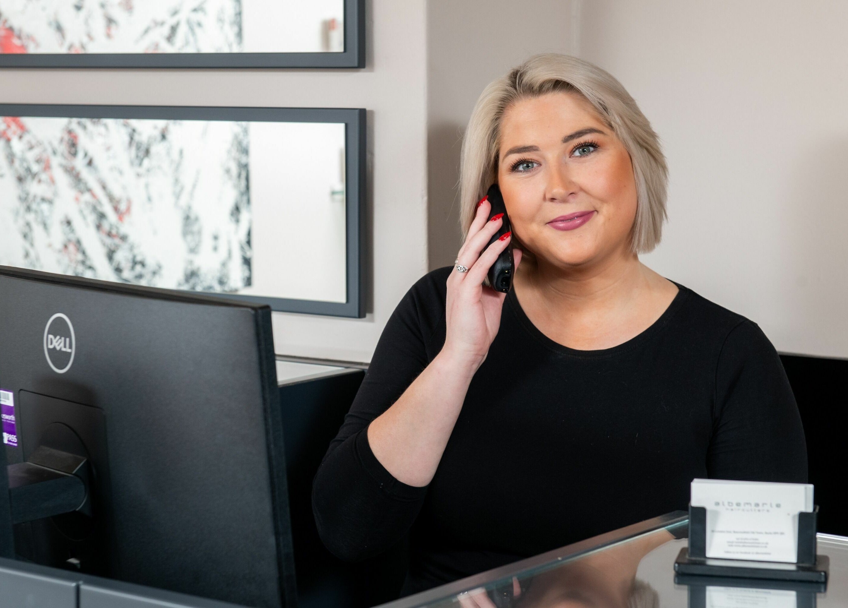 Friendly receptionist at Albemarle Haircutters, Beaconsfield, England, GB in a modern setting.