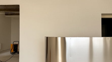 Modern interiér PROFIL Barbershop, Ostrava, Moravskoslezský Kraj, CZ. Minimalistický prostor s kovovým pultem.
