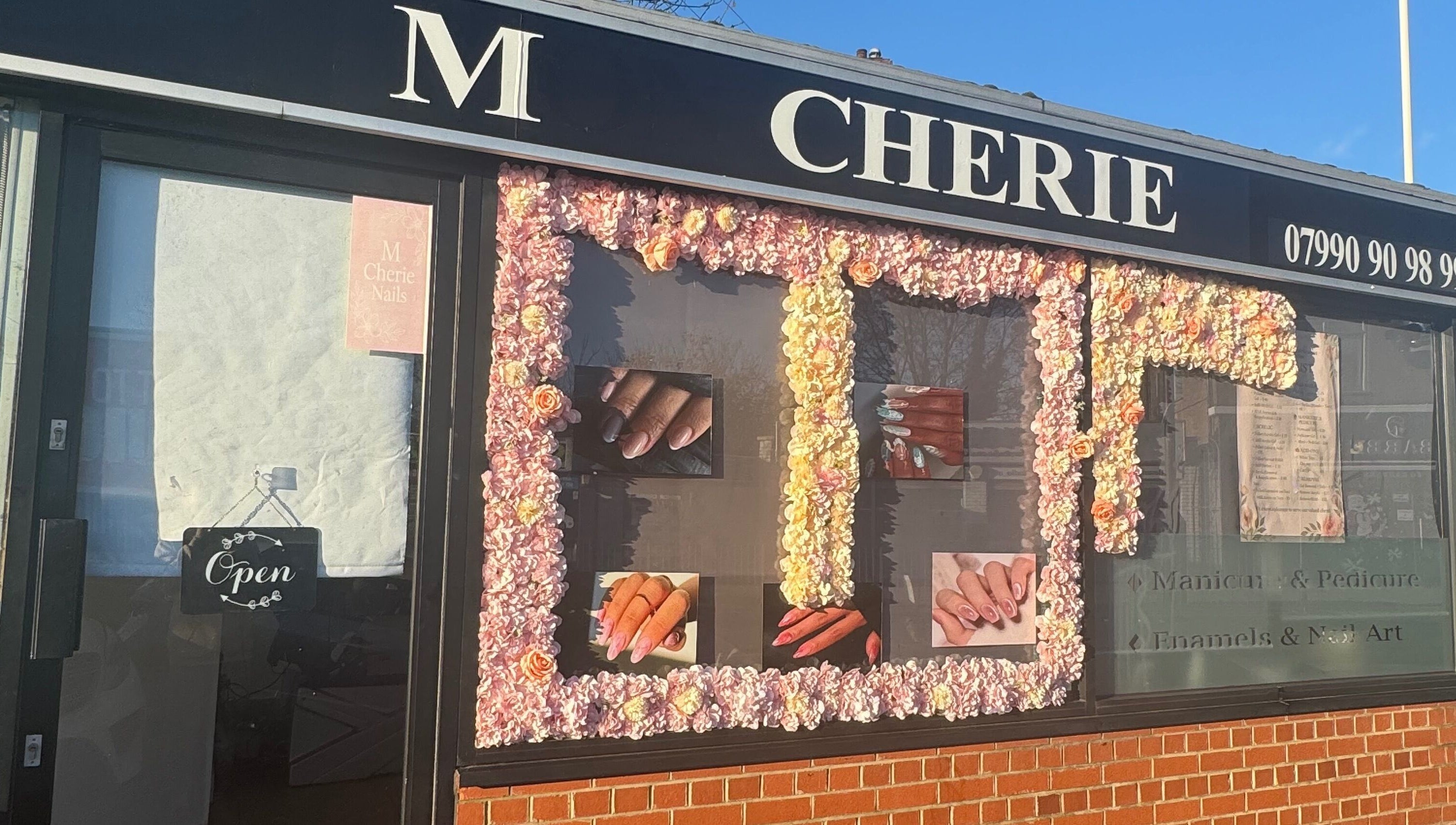 M Cherie Nails trên đường Hornchurch, Anh. Bảng hiệu với nét trang trí hoa ấn tượng.