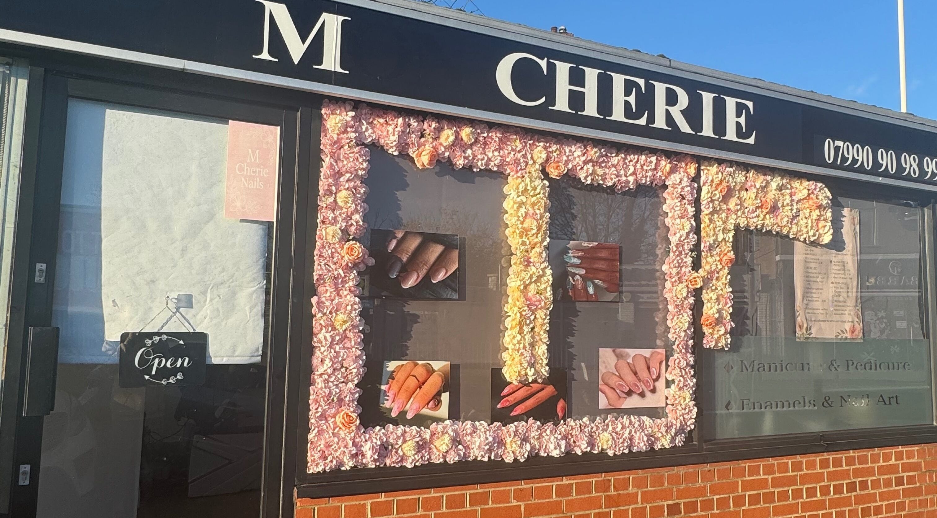 M Cherie Nails trên đường Hornchurch, Anh. Bảng hiệu với nét trang trí hoa ấn tượng.