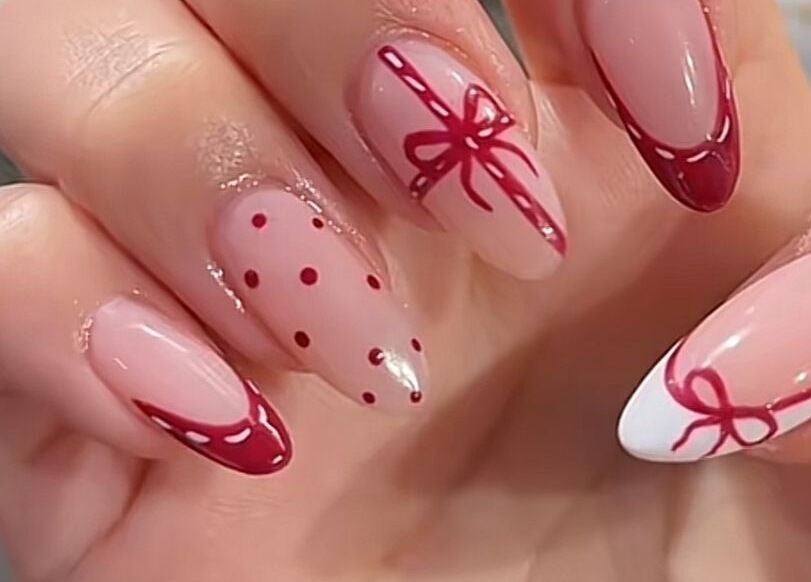 Thiết kế móng tay nghệ thuật tại M Cherie Nails, Hornchurch, England, GB với họa tiết nơ và chấm đỏ.