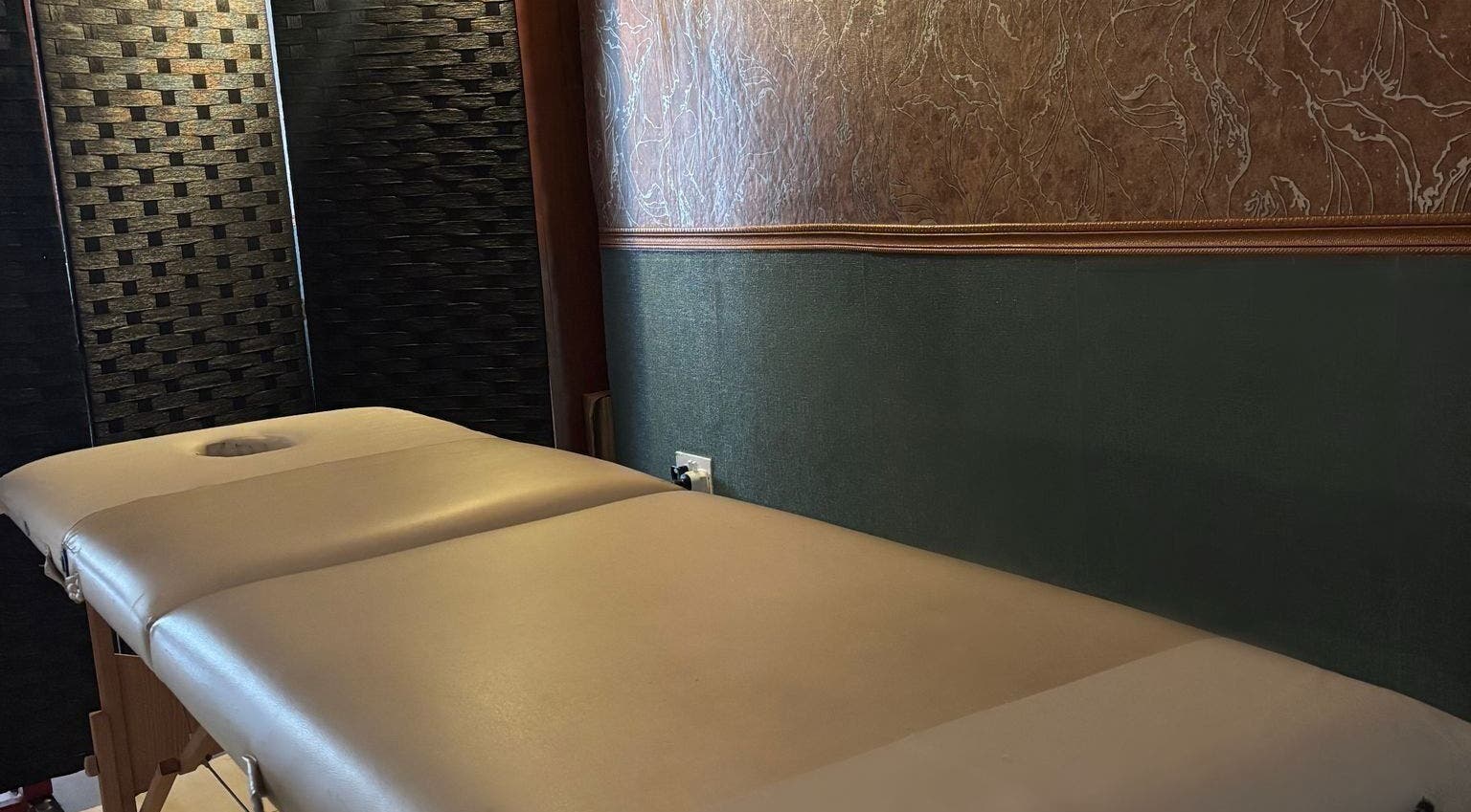 Luxurious massage table at Feniks, Valletta, MT with elegant wall accents for ultimate relaxation.