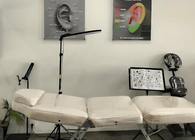 Professional tattoo setup at Kama Piercing & Tattoo Bali, Bali, ID featuring equipment and design charts.