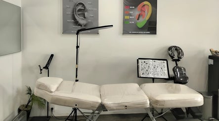 Professional tattoo setup at Kama Piercing & Tattoo Bali, Bali, ID featuring equipment and design charts.