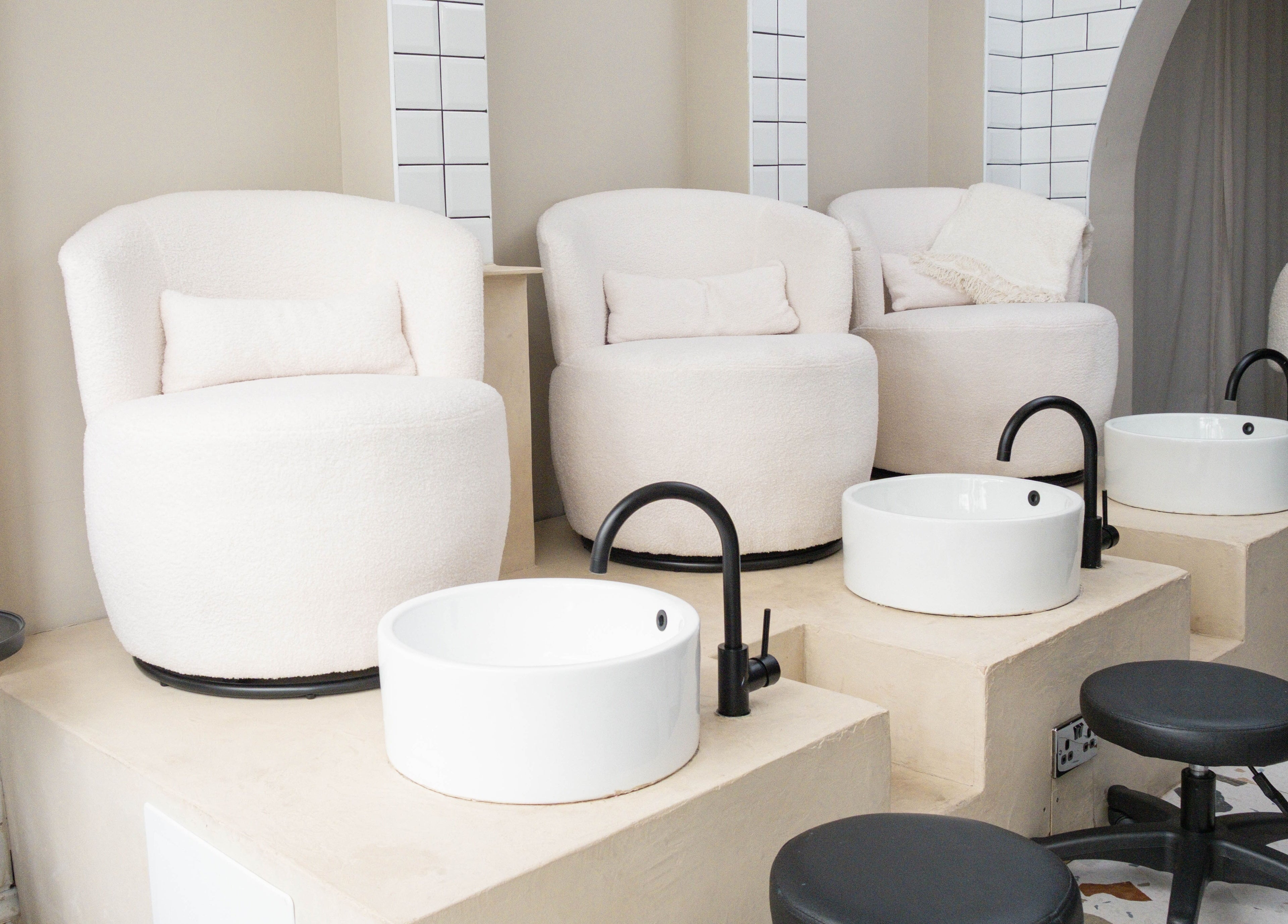 Luxurious pedicure stations at Awe London Shoreditch, London, England, GB, with plush chairs and modern basins.