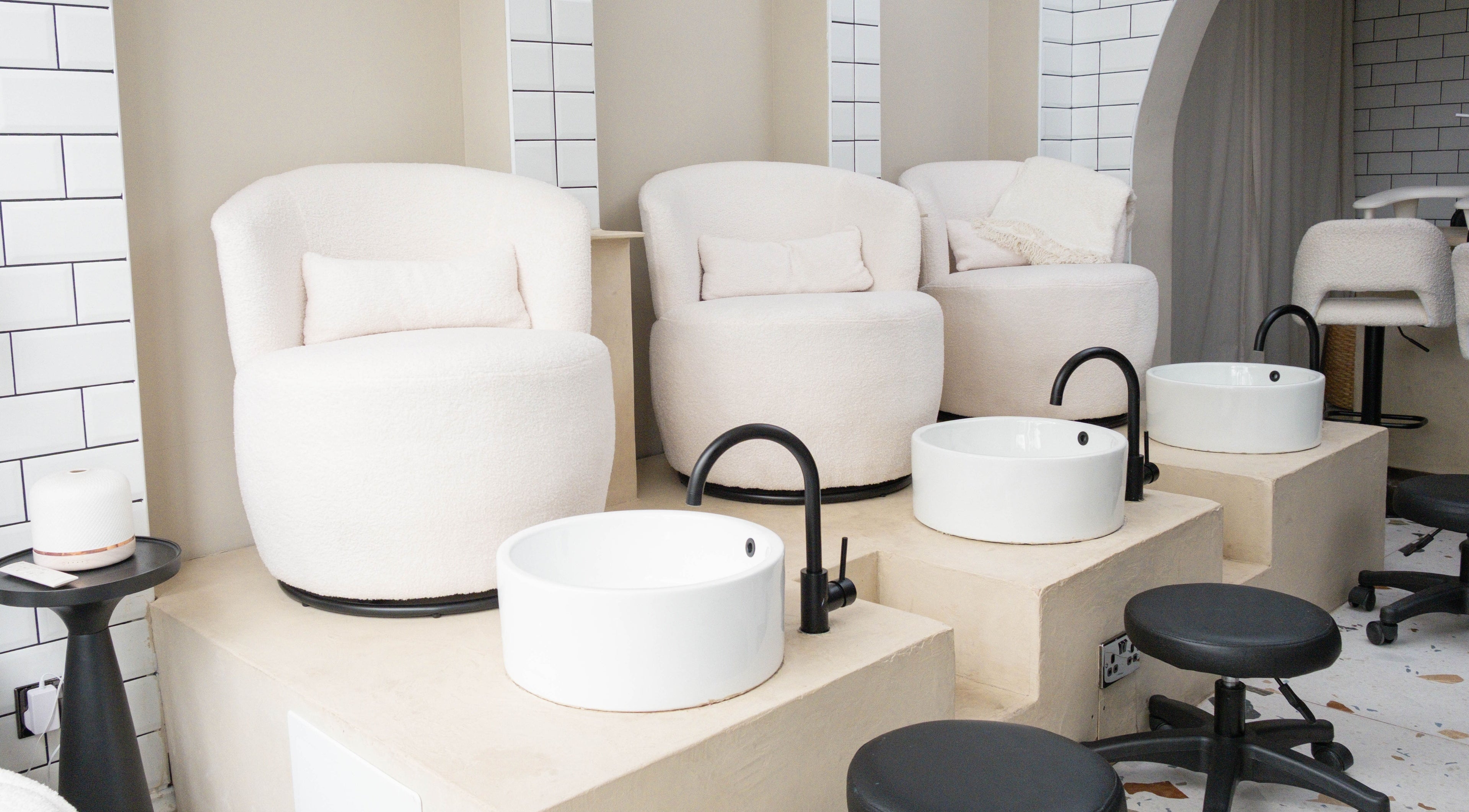 Luxurious pedicure stations at Awe London Shoreditch, London, England, GB, with plush chairs and modern basins.