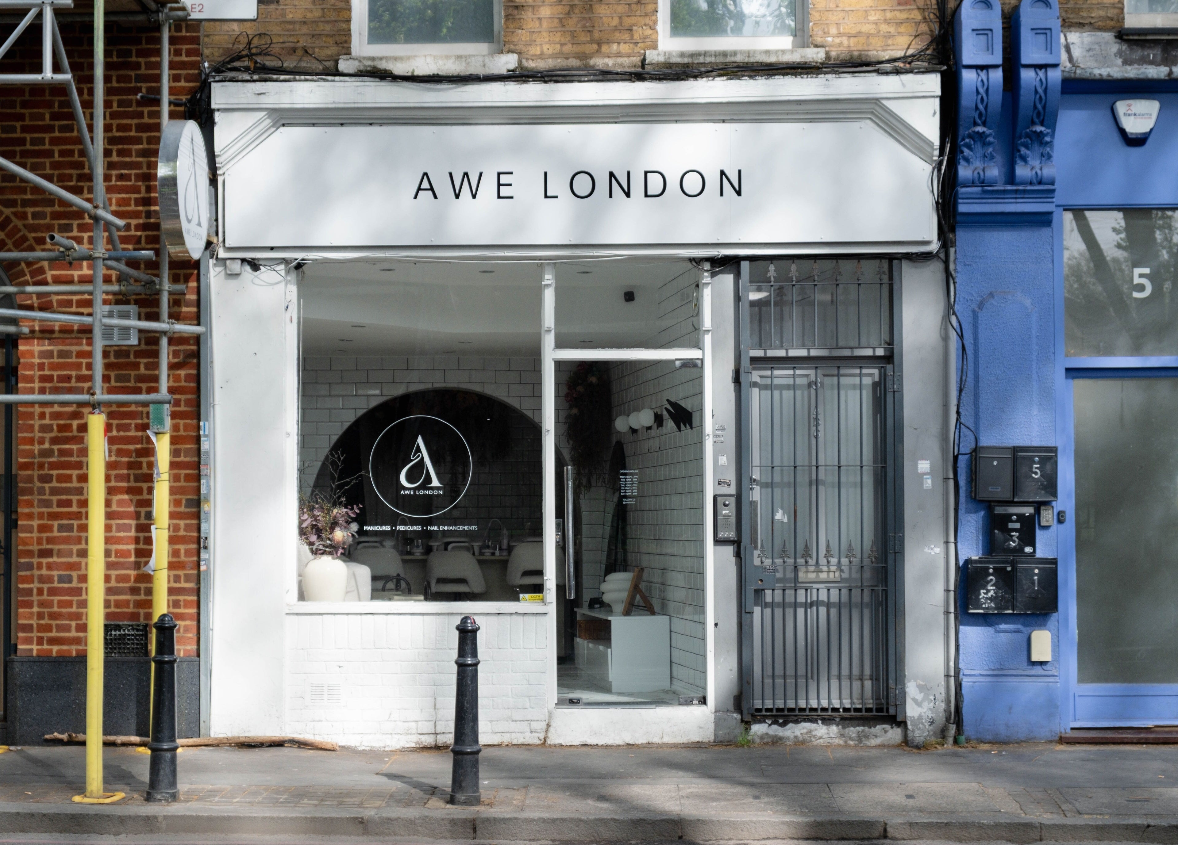 Chic entrance of Awe London Shoreditch beauty salon on a lively street in London, England, GB.