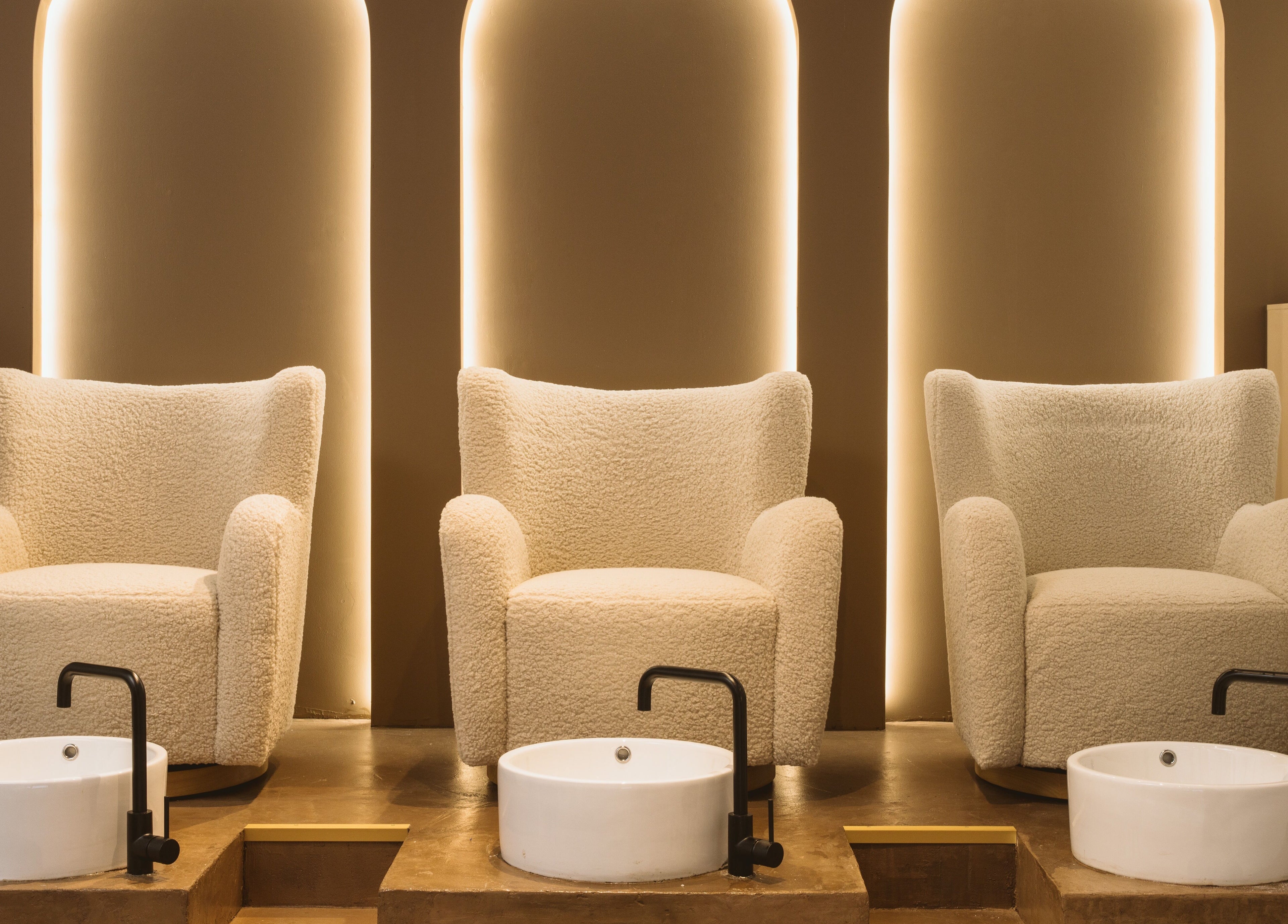 Elegant pedicure chairs at Awe London Canary Wharf in London, England, GB with ambient lighting.