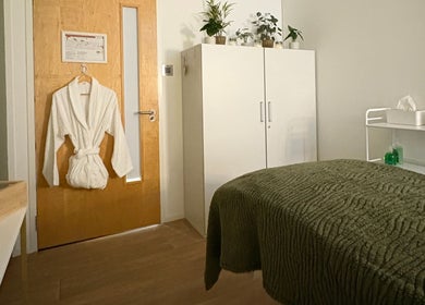 Cozy therapy room at Jessica Bower Wellness, St Albans, England, with robe and green blanket.