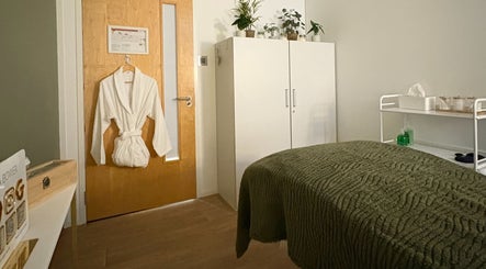 Cozy therapy room at Jessica Bower Wellness, St Albans, England, with robe and green blanket.
