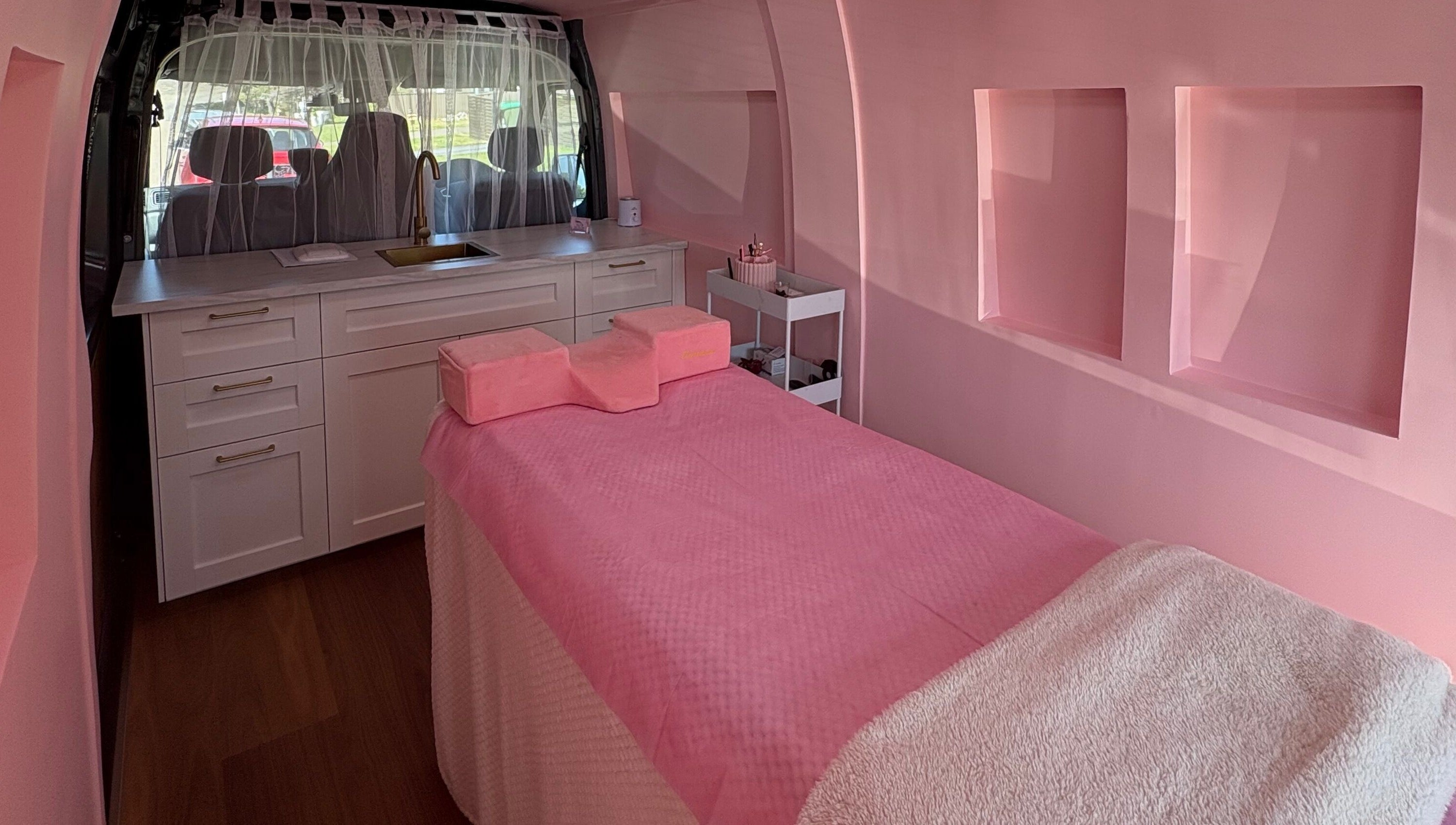 Luxurious interior of The Mobile Lash and Brow Studio, Engadine, New South Wales, AU, with a pink treatment bed.